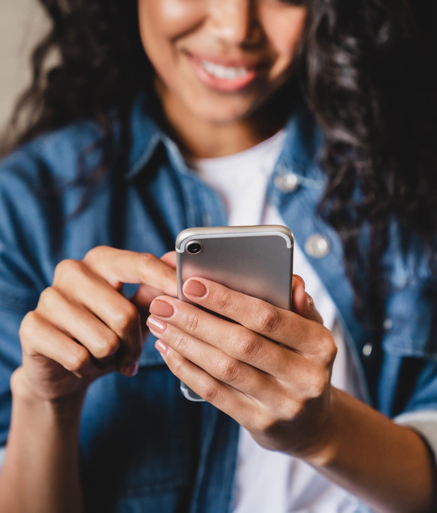 A woman smiling while reading on her phone